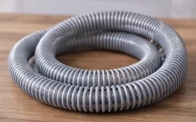 A coiled CPAP hose resting on a wooden surface