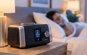 A CPAP machine running on a nightstand while someone sleeps