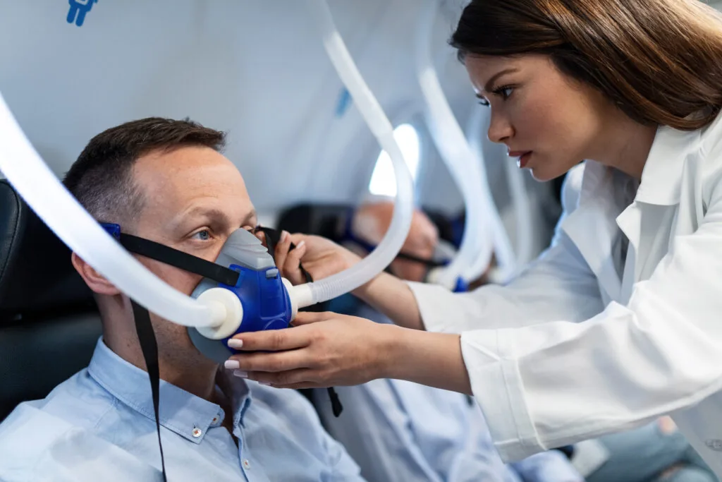 A healthcare professional helping a patient with a respiratory mask